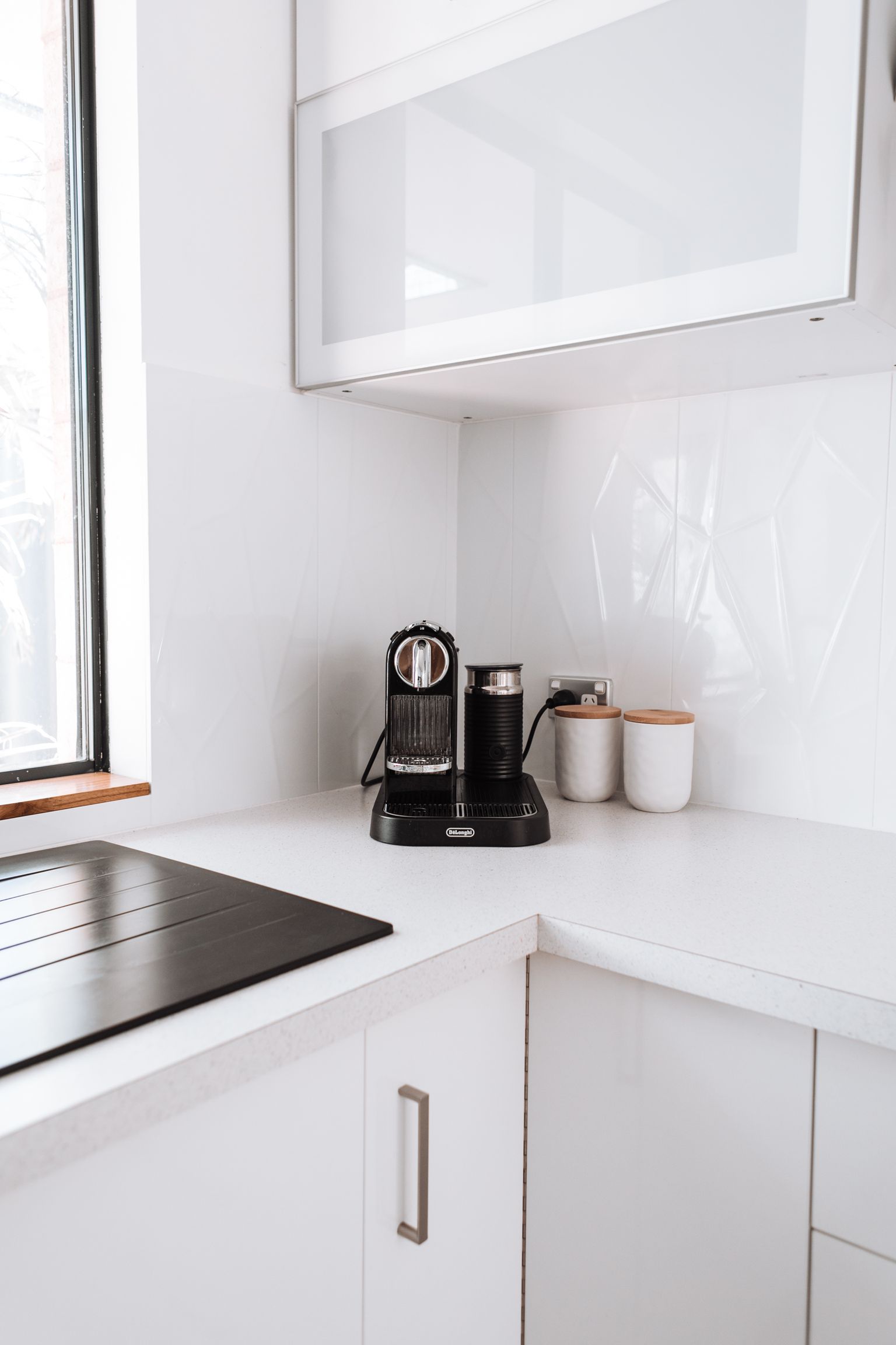 A coffee maker arranged on a bright compact kitchen counter