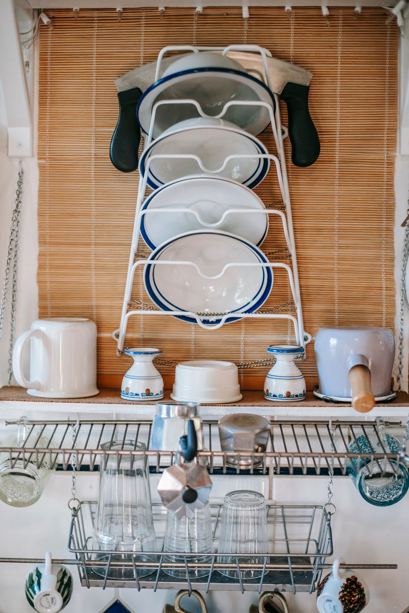 Plates, cups, and glasses on open metal shelves in a lived-in kitchen